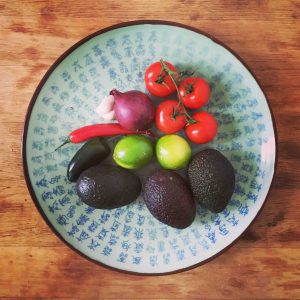 red pepper tomatoes onion avocado lime and garlic before the guacamole
